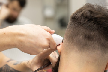 Obraz na płótnie Canvas Young Man in Barbershop Hair Care Service Concept 
