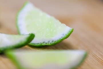 lime slices on wooden table, close up blurry background