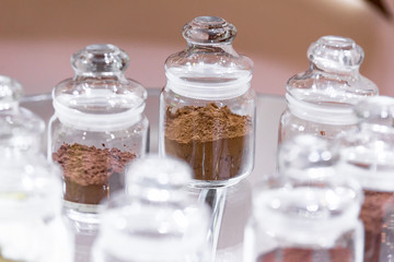Regular and alkalised cocoa powder on with dar chocolate, in glass jars with lids.