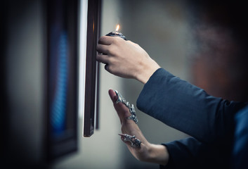 Hands of a psychic with a candle in the process of ritual