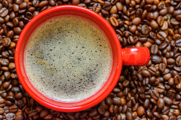 a cup of coffee on a background of coffee beans