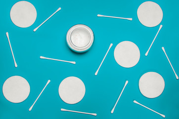Hygiene products: round white cotton pads and cotton swabs are on colored background