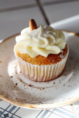 Homemade bakery style vanilla delicious sponge cake with white butter cream cream frosting and almond on top on plate. Candy bar for celebrating partys and birthdays