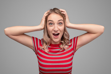 Astonished teenager keeping hands on head