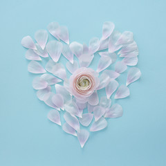 heart of light pink petals on a light blue square textural background with a flower in the center