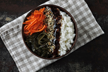 Poké bowl of rice, sea kale and carrots.