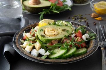 Healthy salad of fresh vegetables - tomatoes, avocado, arugula, egg, spinach. Flat lay. Top view.