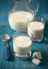 fresh milk in glasses with sugar cubes