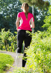 Adult female in pink T-shirt is jogging back