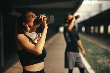Poster Young woman and man drinking protein shake after workout © djile