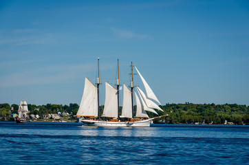 Fototapeta premium Two tall ships under full sail near a coastline