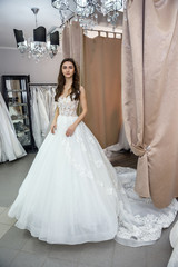Fototapeta na wymiar Woman in wedding dress in full length in store