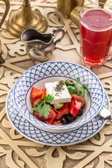 tomato salad with feta cheese and herbs on oriental table