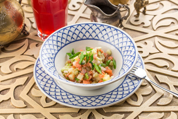 Fresh salad with cucumber, potato and smoked salmon on oriental table