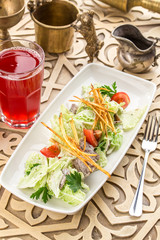 Healthy salad with lettuce, tomatoes and meat on oriental background