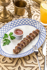 Beef Shish kebab with ketchup on the side on oriental table