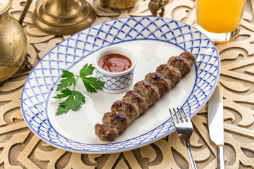 Beef Shish kebab with ketchup on the side on oriental table