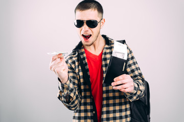 Obraz premium a man in sunglasses with a passport and an origami plane ticket from a Euro bill