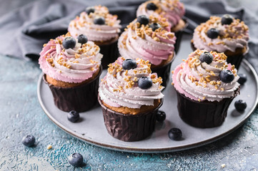 Delicious cupcakes with blueberry cream, fresh blueberries and nut sprinkel.