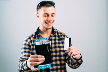Man in shirt with plane tickets credit card and passport in hand