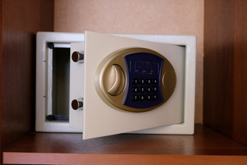 Open safe located on the shelf in the closet. Secure vault code digital lock. The concept of safety of money and valuables. Service at the hotel.