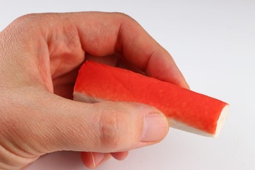 Crab sticks in hand on a white background