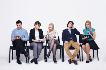 business people waiting in queue sitting in row holding smartphones and cvs, human resources, employment and hiring concept