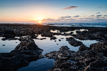 Scenic view of rocky beach  at sunset