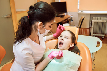 Obraz na płótnie Canvas Pediatric dentistry. Dentist treats teeth of little girl