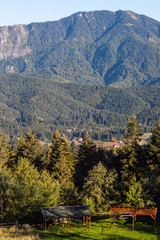 Mountain peak in bright sunlight. Wooden shelters in the foreground
