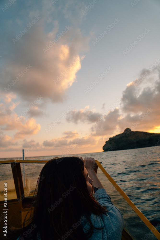 Poster woman travelers on boat in sea at sunset