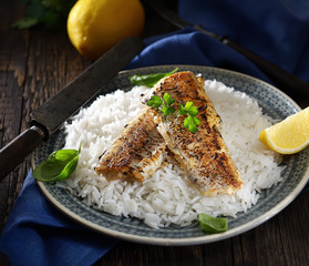 grilled fish fillet with rice on a wooden background. Rustic style.