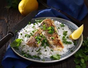 grilled fish fillet with rice on a wooden background. Rustic style.