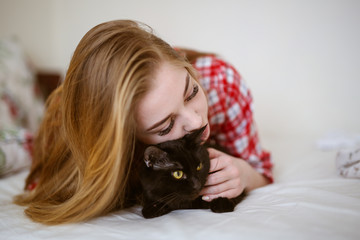 Beautiful woman hugging and playing with cat