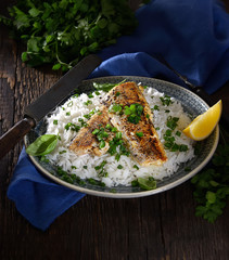 grilled fish fillet with rice on a wooden background. Rustic style.