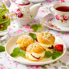Profiterole or cream puff cakes filled with whipped cream and strawberries