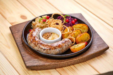 sausage with baked potatoes and salad on the wooden background