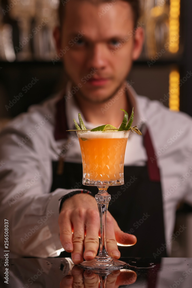 Wall mural bartender is making pisco sour alcohol cocktail drink. pisco sour cocktail drink with ice cubes