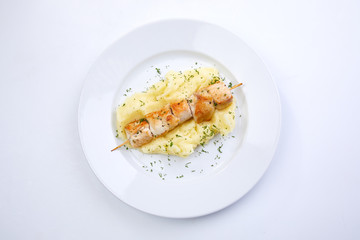 chicken kebab with mashed potato on the white plate