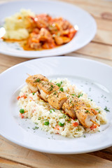 chicken kebab with rice and vegetables on the wooden background