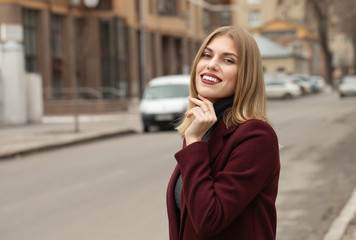 Obraz premium Closeup portrait of young attractive woman outdoors with copy space. Beautiful blond girl model. Cheerful lady on neutral background spring, fall, autumn