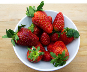  Fresh strawberries in ceramic bowl on rustic wooden table