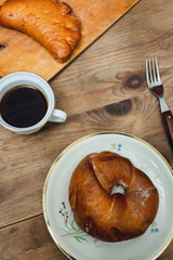Sweet donut and bagel on a plate on wooden table