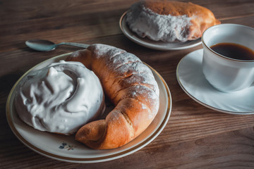 Sweet donut and bagel on a plate on wooden table