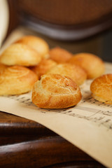 Homemade profiteroles on the music sheet with notes. Profiteroles (choux à la crème) - French choux pastry balls filled with custard or cottage cheese