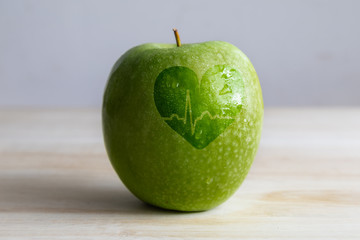 a green apple with a heart and an electrocardiogram wave shape over