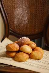 Homemade profiteroles on the music sheet with notes. Profiteroles (choux à la crème) - French choux pastry balls filled with custard or cottage cheese