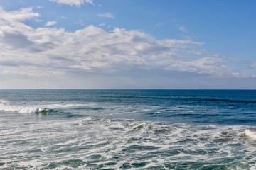 surfers in the ocean against blue sky