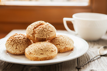 Homemade profiteroles on the music sheet with notes. Profiteroles (choux à la crème) - French choux pastry balls filled with custard or cottage cheese