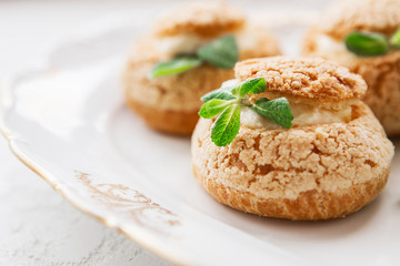 Homemade profiteroles on the music sheet with notes. Profiteroles (choux à la crème) - French choux pastry balls filled with custard or cottage cheese